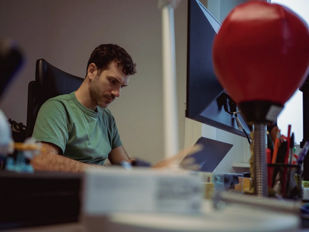 A Peptone scientist working at a desk beside laboratory equipment