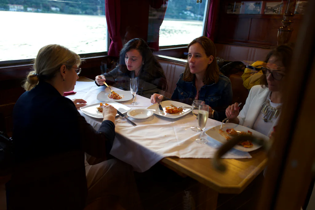 Peptone team members dining in the wood-panelled cabin of a Lake Lugano boat