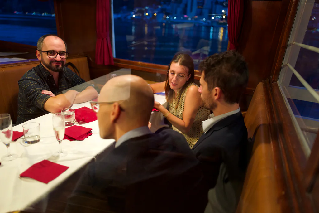 Peptone team members sharing a candlelit dinner aboard a Lake Lugano boat