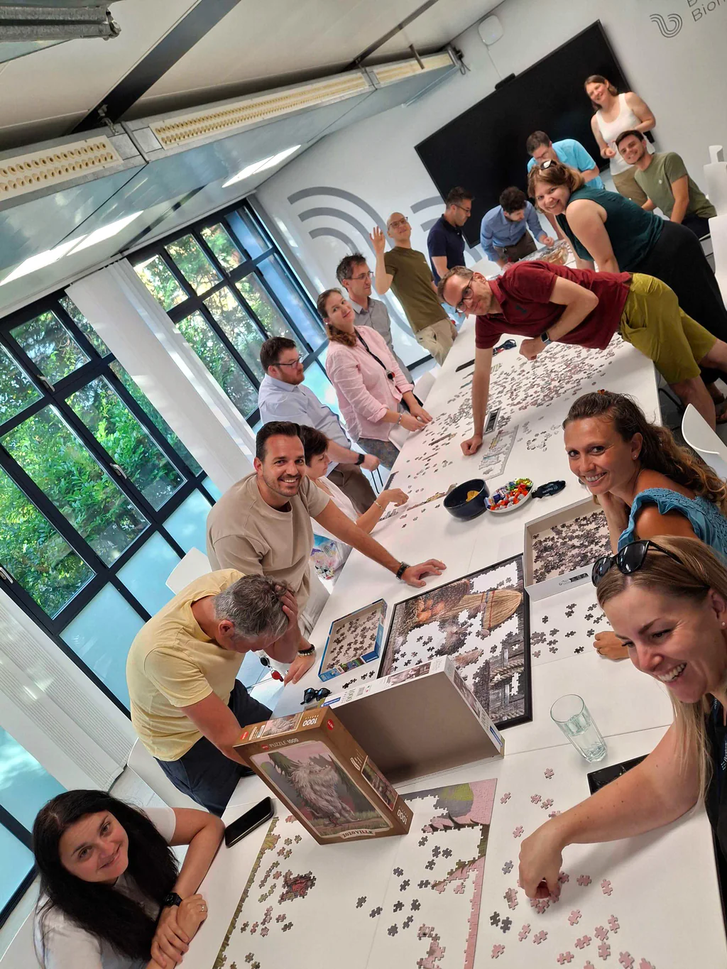 Peptone team members gathered around a long outdoor table during a summer lunch