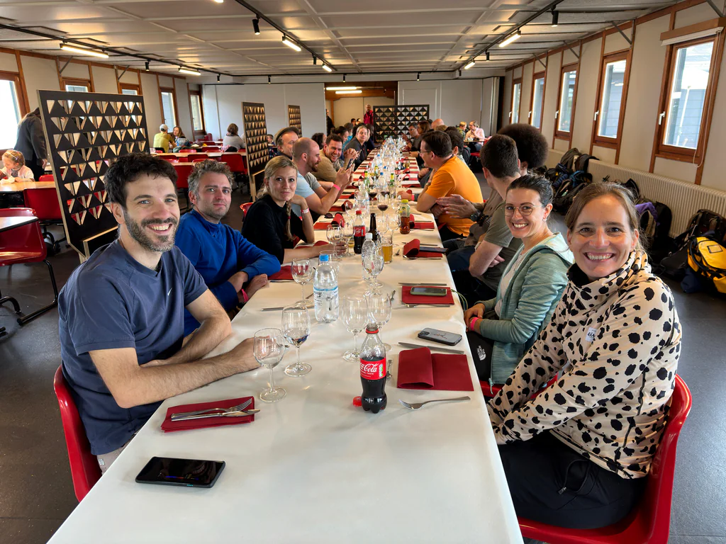 Peptone team members sharing a long table during a group lunch in Ticino
