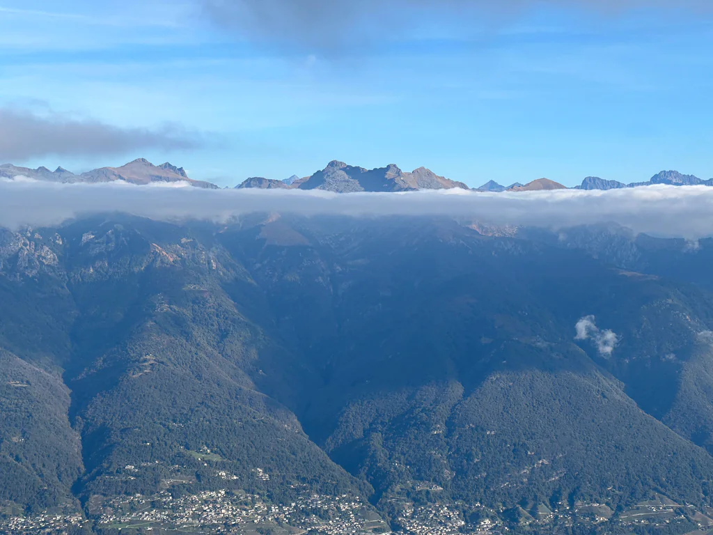 A long band of cloud crossing the mountain ridges above the valleys of Ticino