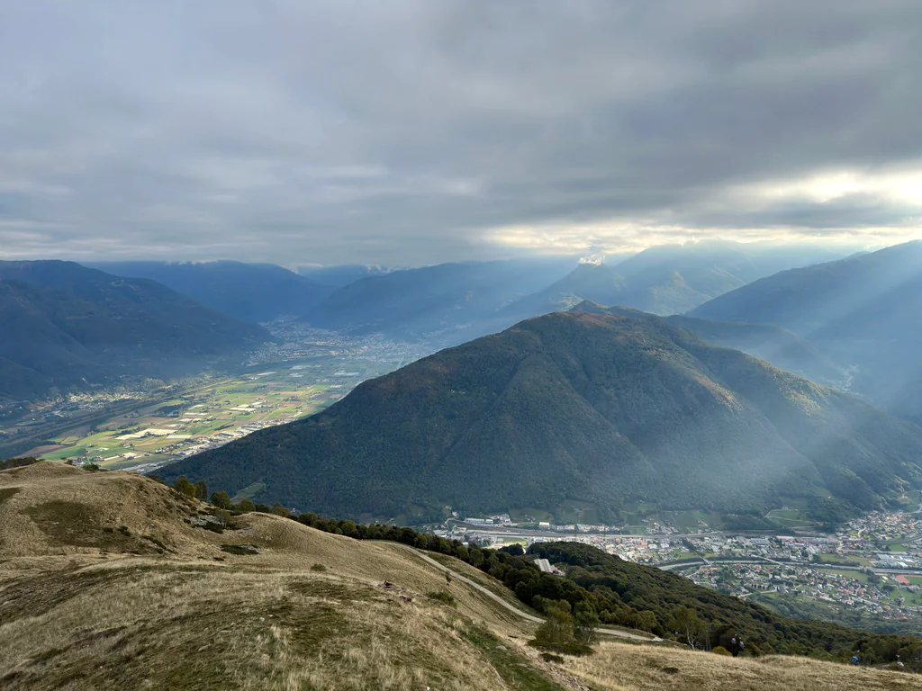 Sunbeams breaking through clouds over the valleys and mountains of Ticino