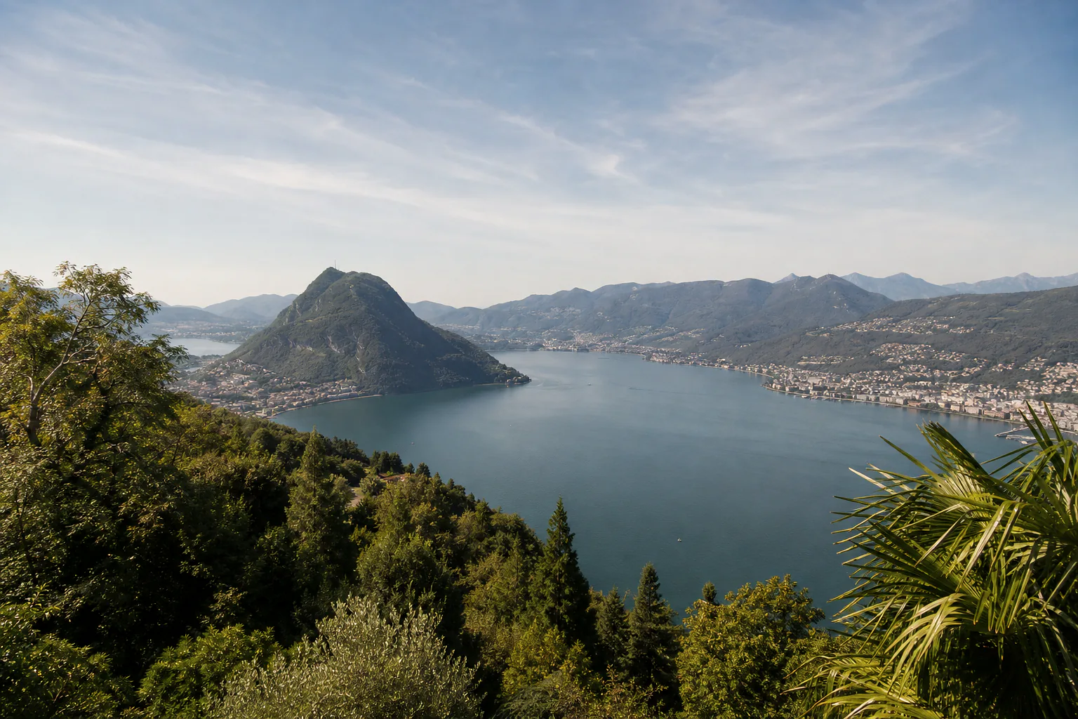 Illustrative AI-generated summer landscape of Lake Lugano and Monte San Salvatore viewed from Monte Bre.